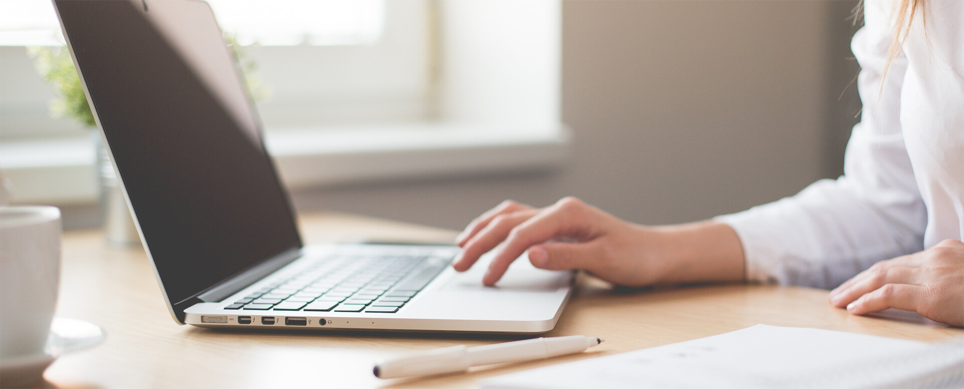 im Vordergrund sieht man ein hölzernes Steuerrad, im Hintergrund blauer Himmel, die Sonne wird durch da Steuerrad verdeckt.