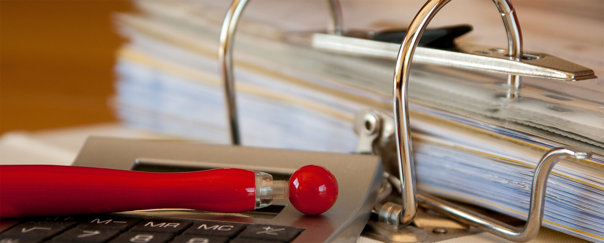 im Vordergrund sieht man ein hölzernes Steuerrad, im Hintergrund blauer Himmel, die Sonne wird durch da Steuerrad verdeckt.